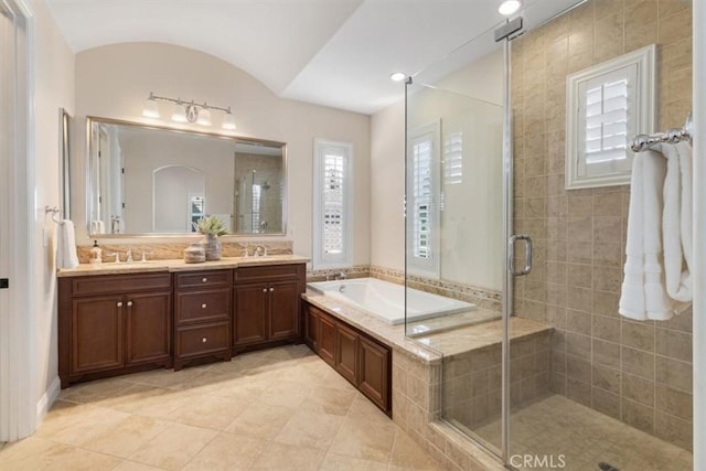 bathroom with tile patterned floors, vanity, separate shower and tub, and lofted ceiling