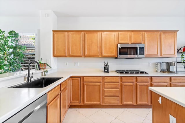 kitchen with sink, light tile patterned flooring, and appliances with stainless steel finishes