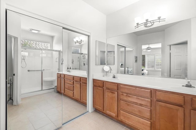 bathroom with a shower with door, vanity, ceiling fan with notable chandelier, and tile patterned flooring