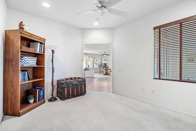 interior space with ceiling fan and light colored carpet