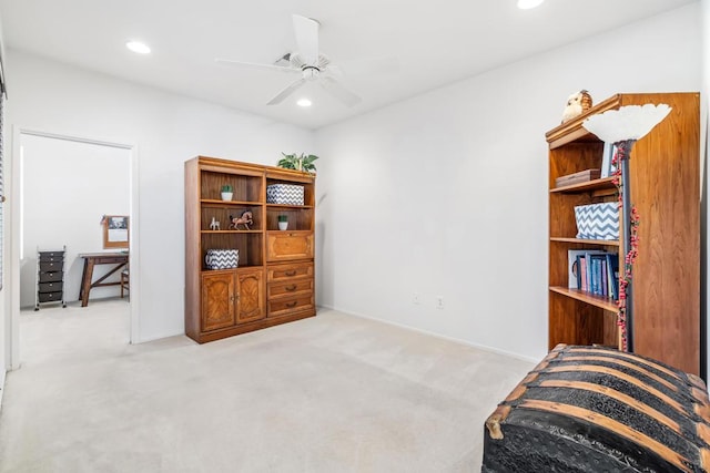 living area featuring light carpet and ceiling fan