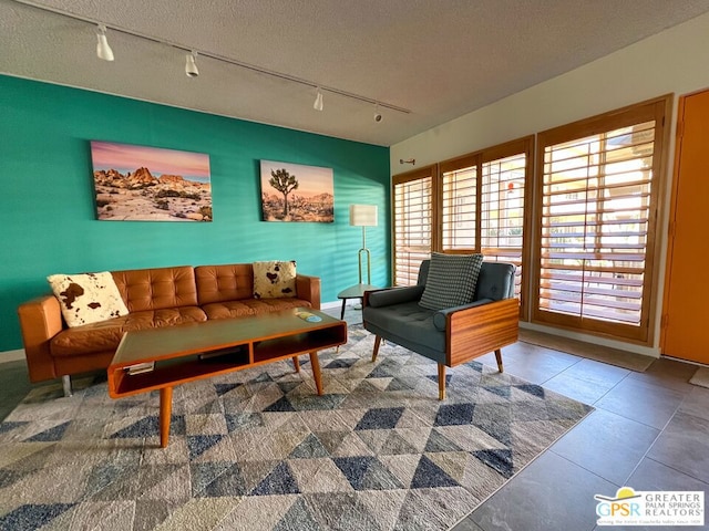 sitting room featuring a textured ceiling, tile patterned floors, and track lighting