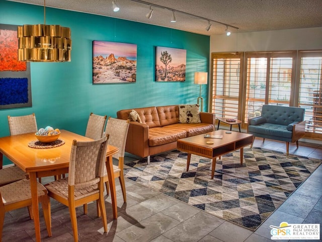 living room with tile patterned floors, track lighting, and a textured ceiling