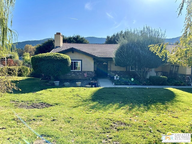 ranch-style house with a mountain view and a front lawn