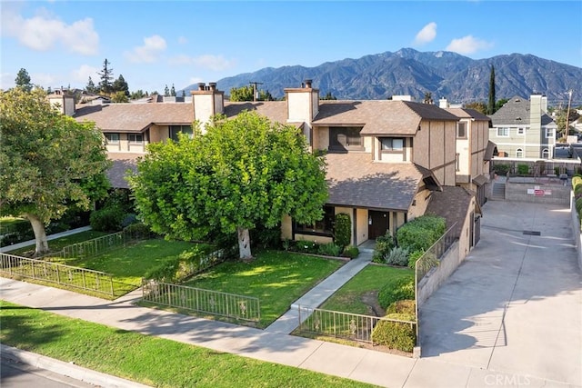 view of front facade with a mountain view and a front yard