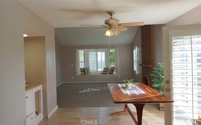 dining area with baseboards, ceiling fan, light colored carpet, lofted ceiling, and light tile patterned floors