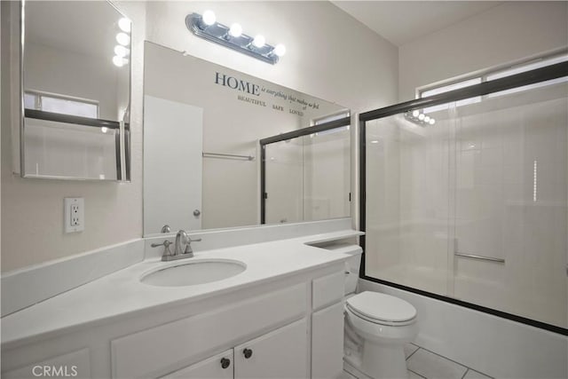 full bathroom featuring tile patterned floors, a wealth of natural light, vanity, shower / bath combination with glass door, and toilet