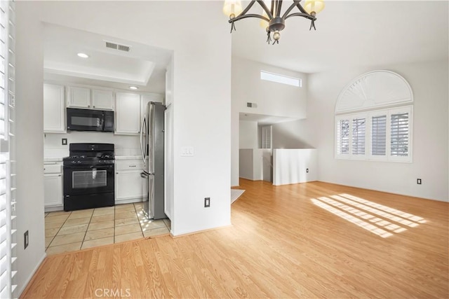 kitchen featuring black appliances, a notable chandelier, white cabinetry, and light hardwood / wood-style flooring