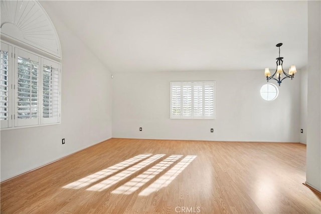 spare room featuring light hardwood / wood-style floors and an inviting chandelier