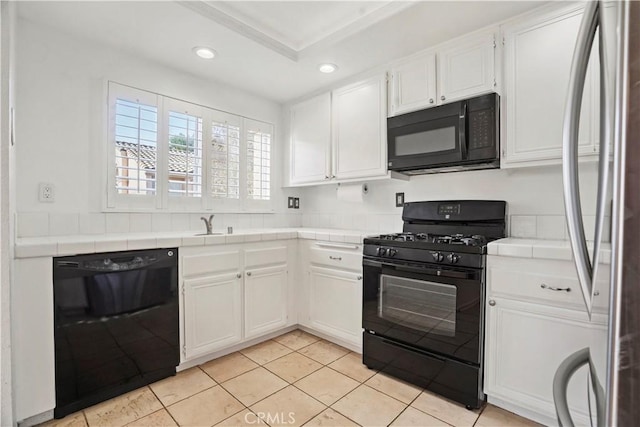 kitchen with black appliances, tile counters, white cabinetry, and light tile patterned floors