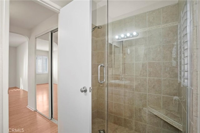 bathroom with wood-type flooring and walk in shower