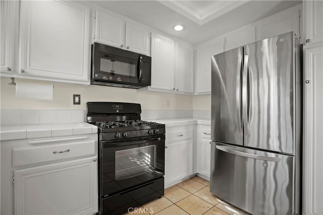 kitchen with tile countertops, white cabinets, and black appliances