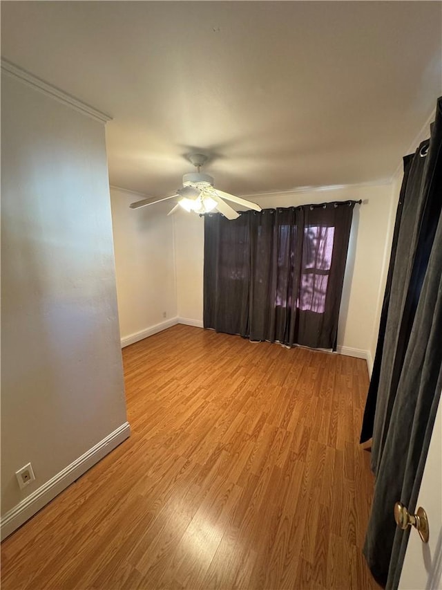 empty room with ceiling fan, light hardwood / wood-style floors, and ornamental molding