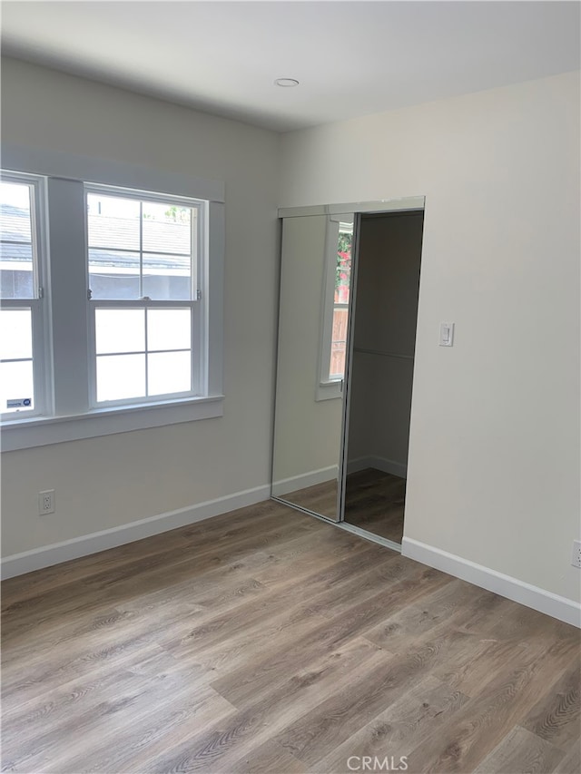 unfurnished bedroom with wood-type flooring and a closet