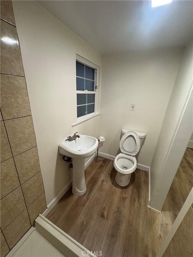 bathroom featuring wood-type flooring and toilet