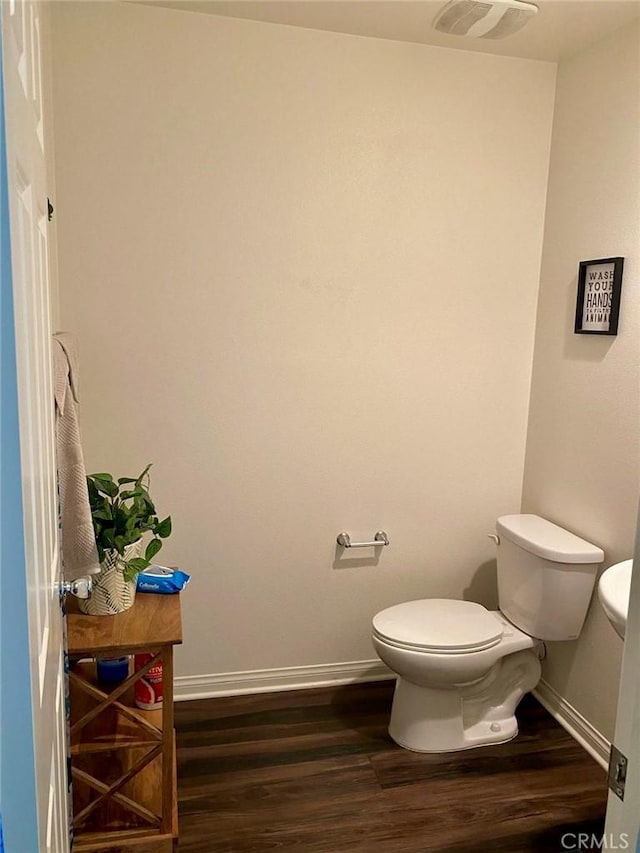 bathroom featuring wood-type flooring and toilet