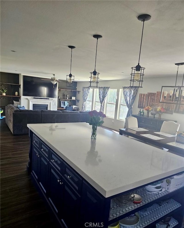 kitchen featuring decorative light fixtures, a kitchen island, and blue cabinets