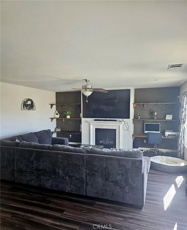 living room with ceiling fan and dark hardwood / wood-style flooring