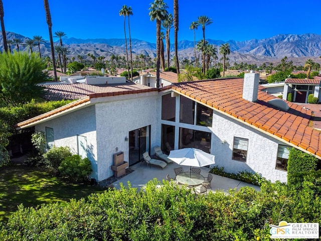 rear view of house with a mountain view and a patio