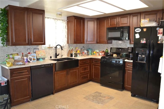 kitchen featuring black appliances, decorative backsplash, light tile patterned flooring, and sink