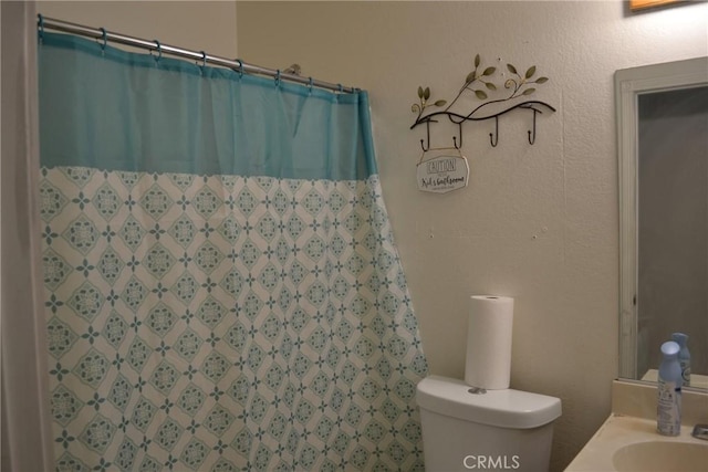 bathroom with vanity, toilet, and curtained shower