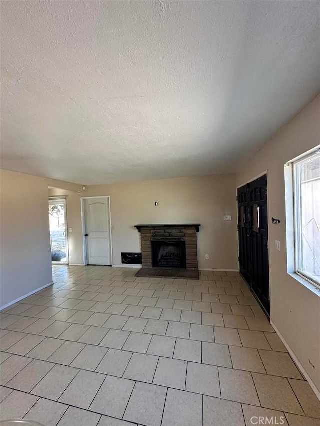 unfurnished living room with a fireplace, plenty of natural light, and a textured ceiling