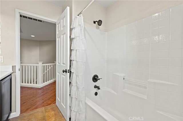 bathroom featuring wood-type flooring, vanity, and shower / tub combo with curtain