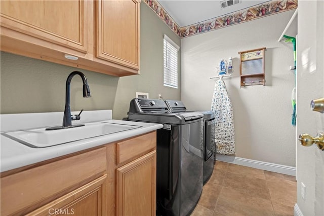 washroom with washing machine and clothes dryer, sink, light tile patterned floors, and cabinets