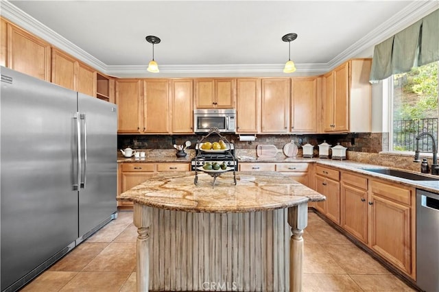 kitchen with appliances with stainless steel finishes, a kitchen island, pendant lighting, and sink