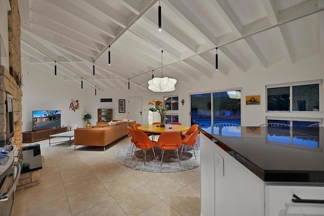 dining room with beam ceiling, light tile patterned floors, and rail lighting