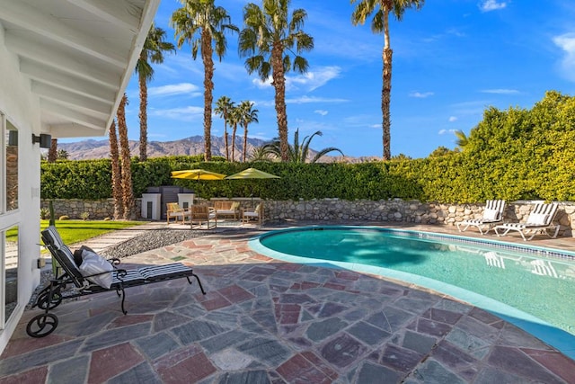 view of swimming pool featuring a mountain view and a patio