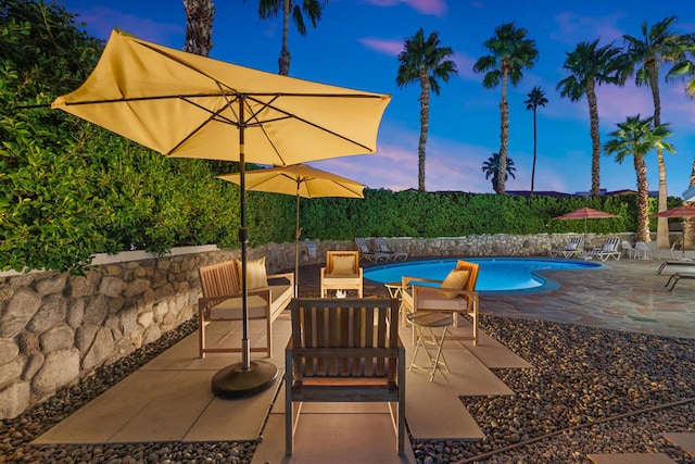 pool at dusk with a patio