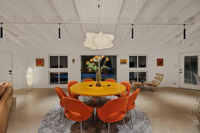 dining room featuring light tile patterned flooring and lofted ceiling with beams