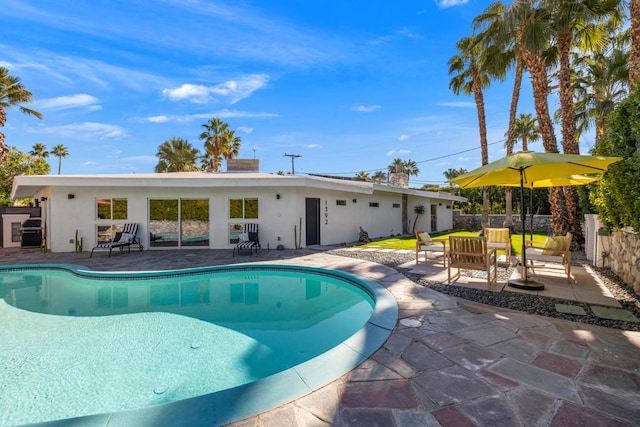 view of swimming pool with a patio area and a grill