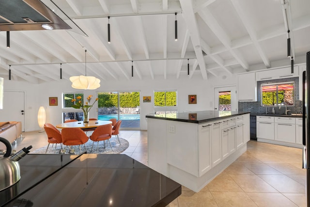 kitchen featuring pendant lighting, beam ceiling, decorative backsplash, white cabinetry, and light tile patterned floors