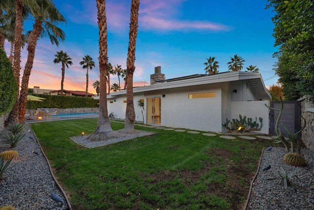 ranch-style house with a yard and a fenced in pool