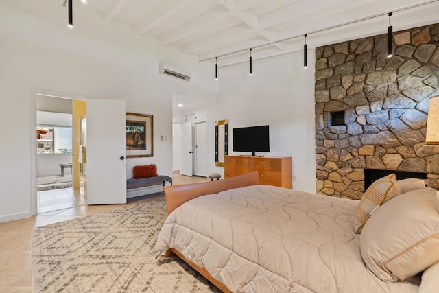 tiled bedroom with a wall mounted AC, a fireplace, and beamed ceiling