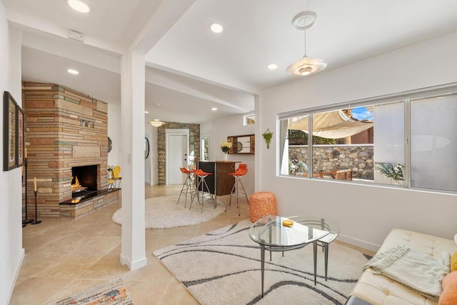 tiled living room featuring beam ceiling and a fireplace