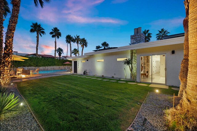 yard at dusk with a fenced in pool