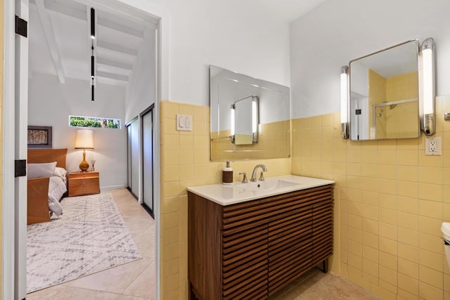 bathroom featuring tile walls, vanity, beamed ceiling, and tile patterned flooring