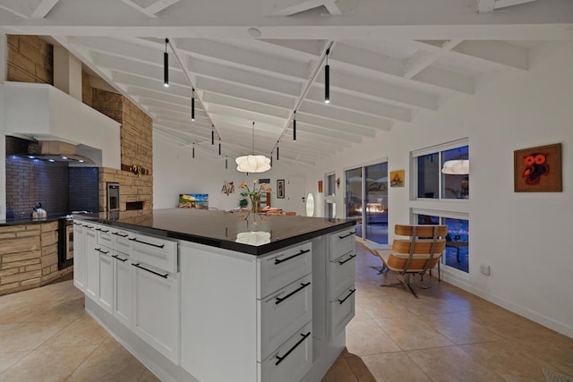 kitchen with decorative light fixtures, a kitchen island, vaulted ceiling with beams, light tile patterned flooring, and white cabinets