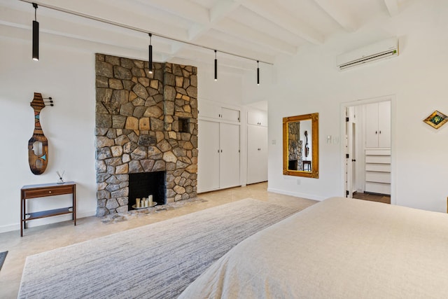 tiled bedroom with a stone fireplace, an AC wall unit, and beamed ceiling