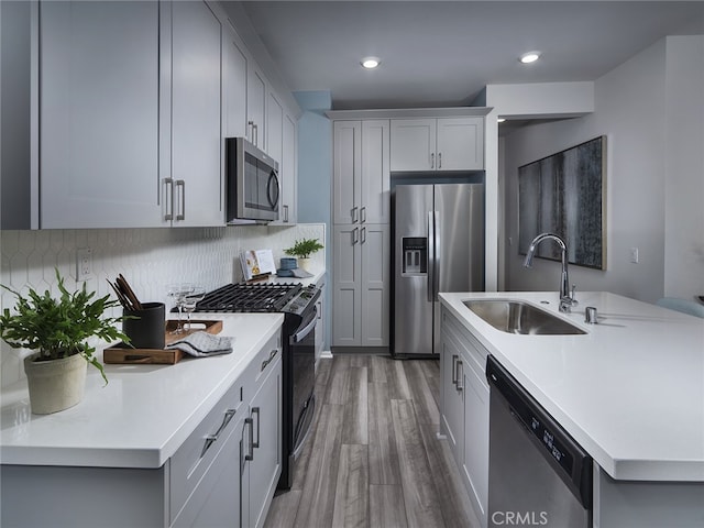 kitchen featuring decorative backsplash, dark hardwood / wood-style flooring, stainless steel appliances, and sink