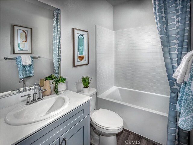 full bathroom with hardwood / wood-style floors, vanity, shower / bathtub combination, and toilet