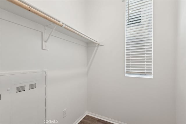 laundry room with baseboards and wood finished floors