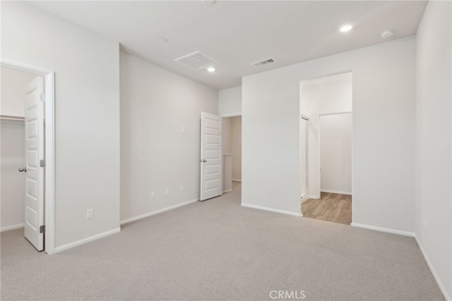 unfurnished bedroom with a closet, visible vents, a spacious closet, and baseboards