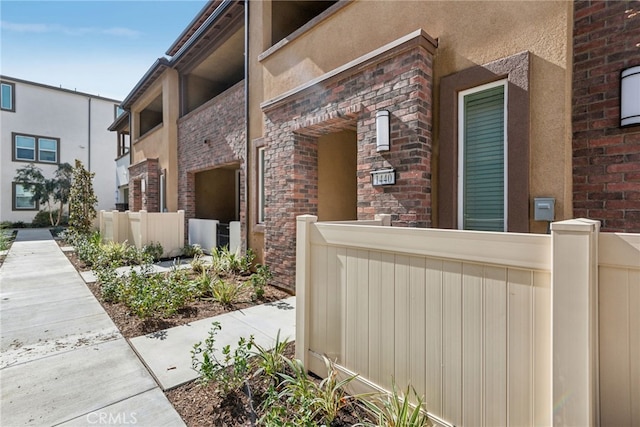 entrance to property with fence and brick siding