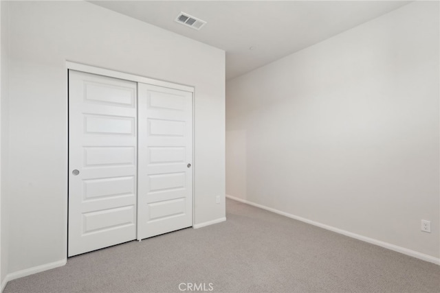 unfurnished bedroom featuring light carpet, visible vents, and baseboards