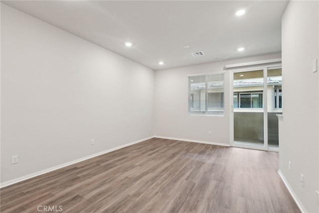 unfurnished room with baseboards, visible vents, wood finished floors, and recessed lighting