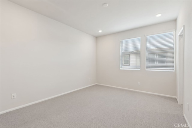 carpeted empty room featuring recessed lighting and baseboards